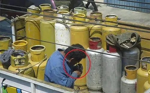 balones-de-gas-empleado-fumador-prendiendo-cigarro-encendedor