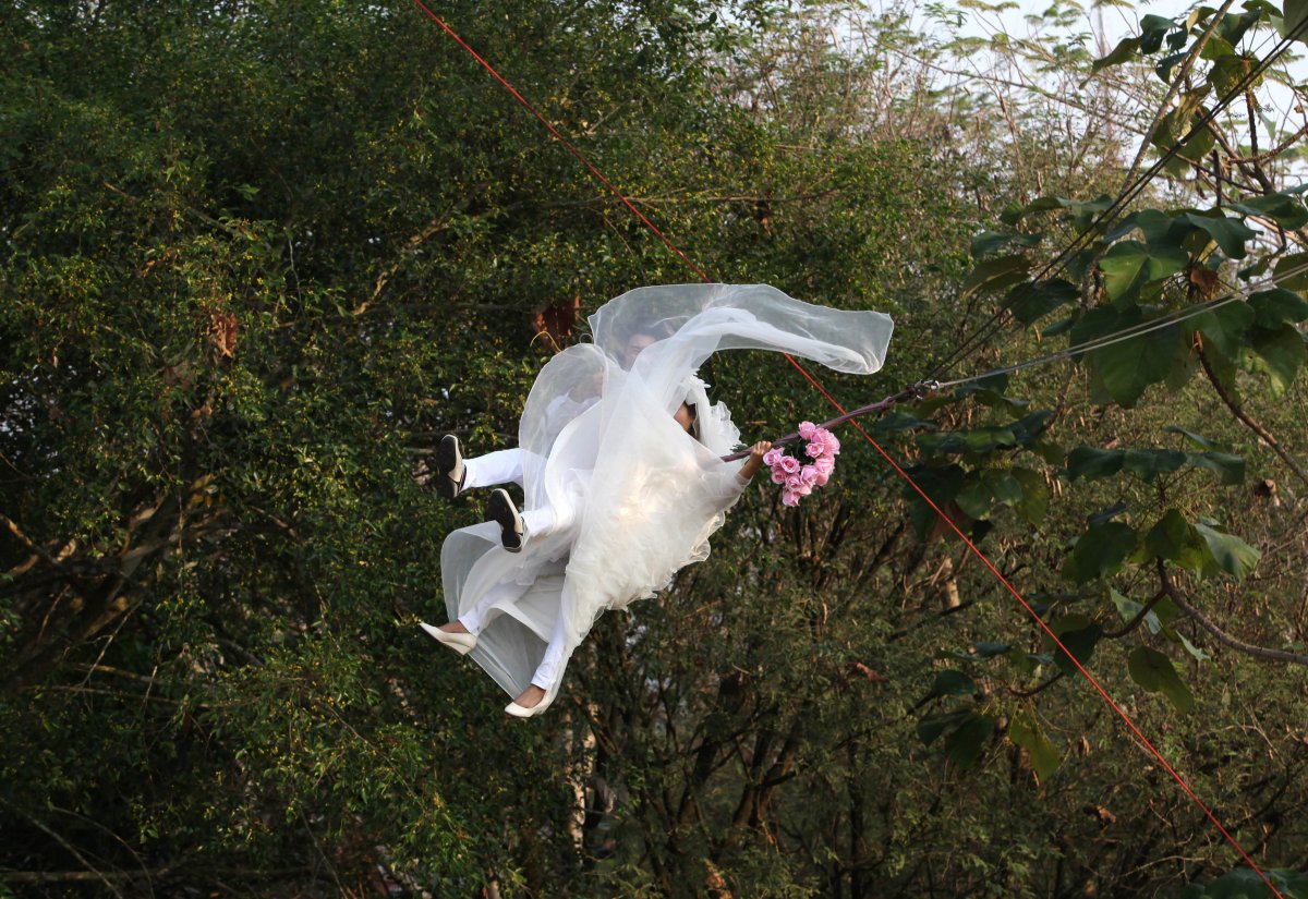 a-thai-bride-and-groom-fly-while-attached-to-cables-during-a-wedding-ceremony-just-before-valentines-day-in-prachin-buri-province-east-of-bangkok
