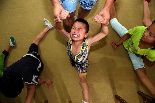 06 Aug 2015, China --- (150806) -- LINQUAN, Aug. 6, 2015 (Xinhua) -- Students practise basic skills at an acrobatic school in Linquan, east China's Anhui Province, Aug. 6, 2015. Acrobatics has become a major way for most local people to acquire a well-off life, and plenty of leftover children here are sent to acrobatic school at a very young age. (Xinhua/Liu Junxi) (hgh) --- Image by © Liu Junxi/Xinhua Press/Corbis