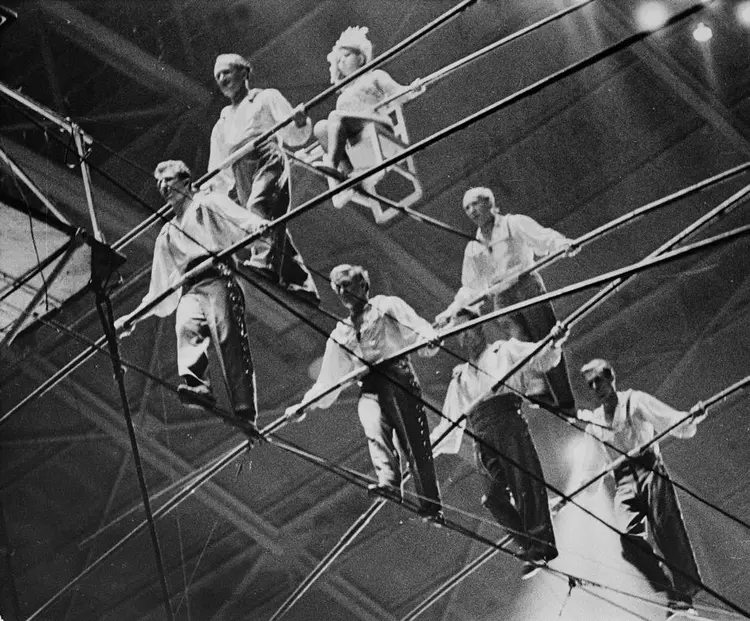 The Great Wallendas circus troupe walk the high wire during their three-tier seven-man pyramid performance at the State Fair Coliseum in Detroit, Michigan on Jan. 30, 1962.  From left to right, bottom row, are, Dieter Schepp, 23; Mario Wallenda, 21; Richard Faughnan, 29; Gunther Wallenda, 42.  Second row, left to right, Karl Wallenda, 57; Herman Wallenda, 60.  Sitting on chair is Jana Schepp, 17.  Karl's son-in-law Faughnan and nephew Schepp were killed when the pyramid formation collapsed and the performers fell to the ground.  Dieter's sister Jana and Karl's son Mario were injured.  (AP Photo)