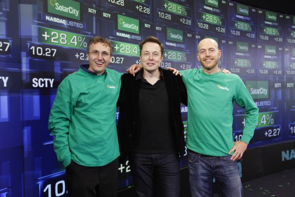 IMAGE DISTRIBUTED FOR SOLARCITY - SolarCity Founder & CEO Lyndon Rive, Chairman Elon Musk, and SolarCity Founder & COO Peter Rive celebrate the companyís IPO by posing for a photo at the NASDAQ Stock Market on Thursday, Dec. 13, 2012 in New York. SolarCity is a leader of distributed clean energy and will trade under SCTY. (Mark Von Holden/AP Images for SolarCity) ORG XMIT: CPA106