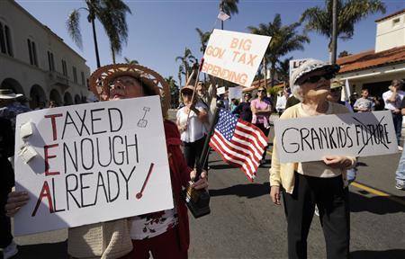 Anita Dwyer (L) and Bea Severson hold signs as they participate in a rally and march in protest of higher taxes in Santa Barbara, California
