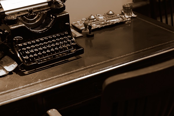 It is an old typewriter for bank on the desk.