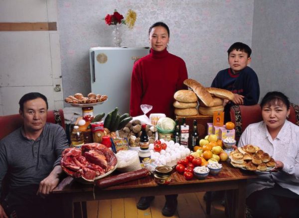 MON01.0001.xxf1s (MODEL RELEASED IMAGE) The Batsuuri family in their single-room home—a sublet in a bigger apartment—in Ulaanbaatar, Mongolia, with a week’s worth of food. Standing behind Regzen Batsuuri, 44 (left), and Oyuntsetseg (Oyuna) Lhakamsuren, 38, are their children, Khorloo, 17, and Batbileg, 13. Cooking methods: electric stove, coal stove. Food preservation: refrigerator-freezer (shared, like the stoves, with two other families). /// The Batsuuri family is one of the thirty families featured in the book Hungry Planet: What the World Eats (p. 226). Food expenditure for one week: $40.02 USD. (Please refer to Hungry Planet book p. 227 for the family’s detailed food list.)