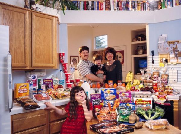 USca01.0001.xxf1s (MODEL RELEASED IMAGE) The Caven family in the kitchen of their home in American Canyon, California, with a week’s worth of food. Craig Caven, 38, and Regan Ronayne, 42 (holding Ryan, 3), stand behind the kitchen island; in the foreground is Andrea, 5. Cooking methods: electric stove, microwave, outdoor BBQ. Food preservation: refrigerator-freezer, freezer. Favorite foods—Craig: beef stew. Regan: berry yogurt sundae (from Costco). Andrea: clam chowder. Ryan: ice cream. /// The Caven family is one of the thirty families featured in the book Hungry Planet: What the World Eats (p. 260). Food expenditure for one week: $159.18 USD. (Please refer to Hungry Planet book p. 261 for the family’s detailed food list.)