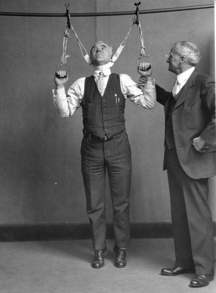Post Office Department Inspector DF Angier (left) and Dr LF Kebler, formerly of the Food & Drug Adminstration, are trying out a stretching device alleged to effect an increase in height from 2 to 6 inches, Washington DC, February 4, 1931. (Photo by PhotoQuest/Getty Images)