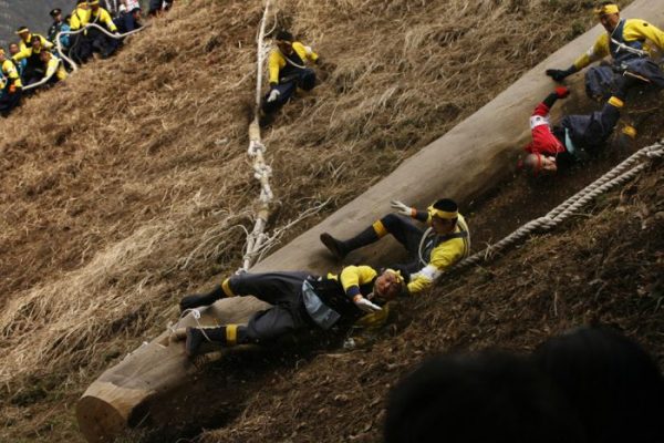 Shrine parishioners fall off a log called "Onbashira" when riding it down a hill as part of delivering it to a Shinto shrine during the Onbashira Festival in Shimosuwa, east of Tokyo, Japan, Friday, April 9, 2010. Those parishioners carry 16 logs to the four Suwa Grand Shrines, four logs to each shrine, to spiritually renew the shrines in the two-and-a-half-month-long festival. The festival takes place every seven years. (AP Photo/ Hiro Komae)