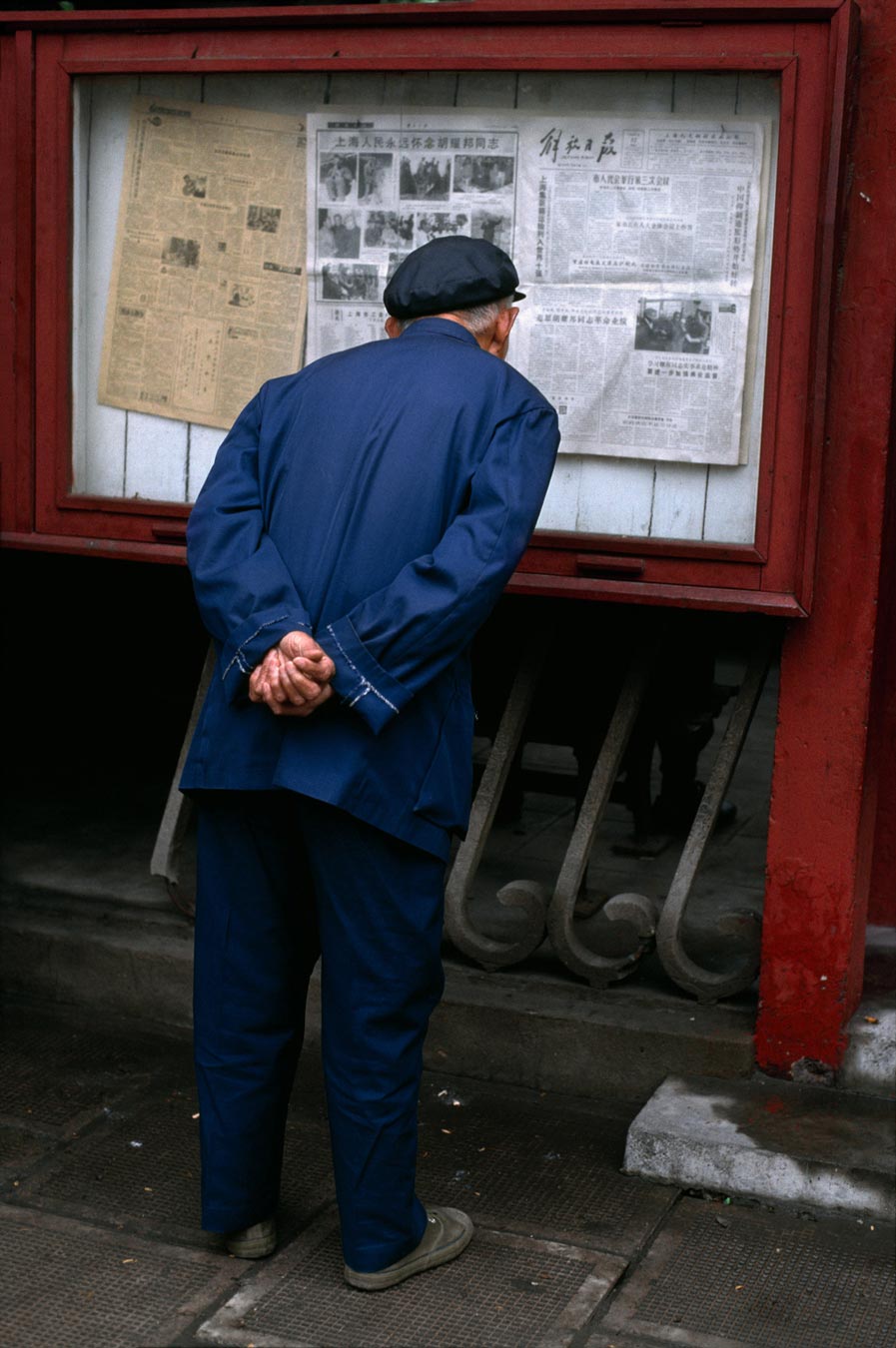 An elderly man reads a posting of the newspaper, China, 04/1989
