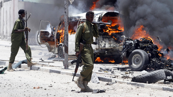 Policemen walk past the scene of an explosion near the presidential palace in Somalia's capital Mogadishu