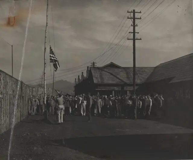 1087px-Flag_Raising_After_POW_Camp_Liberation_1945_9044196508-640x530