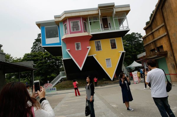 visitors-pose-in-front-of-a-three-story-upside-down-family-sized-house-at-the-huashan-creative-park-in-taipei-taiwan