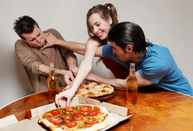 The cheerful company of youth eating a pizza
