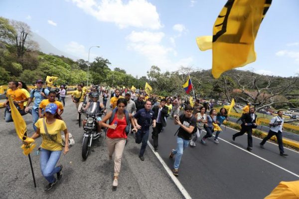Opposition supporters run as they block a highway during a protest against Venezuela's President Nicolas Maduro's government in Caracas, Venezuela April 3, 2017. REUTERS/Carlos Garcia Rawlins
