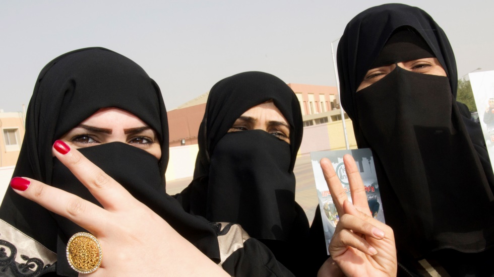 Kuwaiti girls give a victory sign as they stand in front of a polling station in Jahra February 2, 2012. Kuwaitis headed to the polls on Thursday for the fourth time in six years in a snap parliamentary election in which opposition candidates expect to expand their influence and push for change in the oil-exporting Gulf Arab state. REUTERS/Stephanie McGehee (KUWAIT - Tags: POLITICS ELECTIONS)