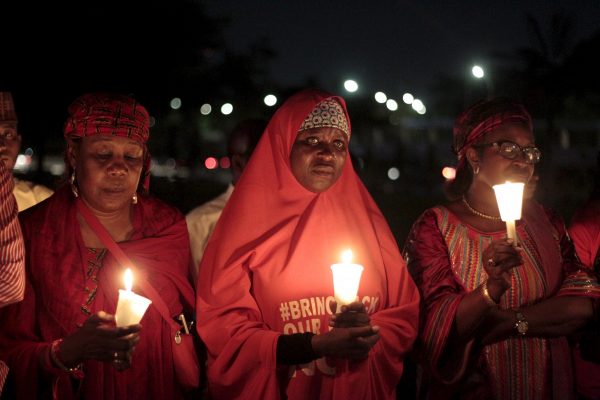 Bring Back Our Girls (BBOG) campaigners raise up candles during a candle light gathering marking the 500th day since the abduction of girls in Chibok, along a road in Abuja