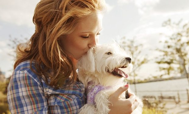 Woman kissing her dog