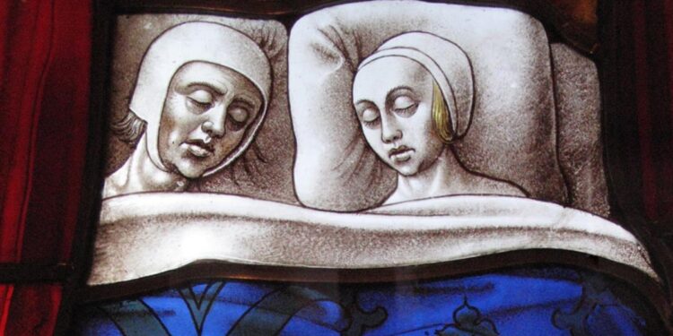 Medieval stained glass church window panel showing a married couple sleeping